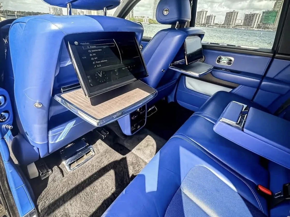Blue Rolls-Royce rear executive lounge with screens